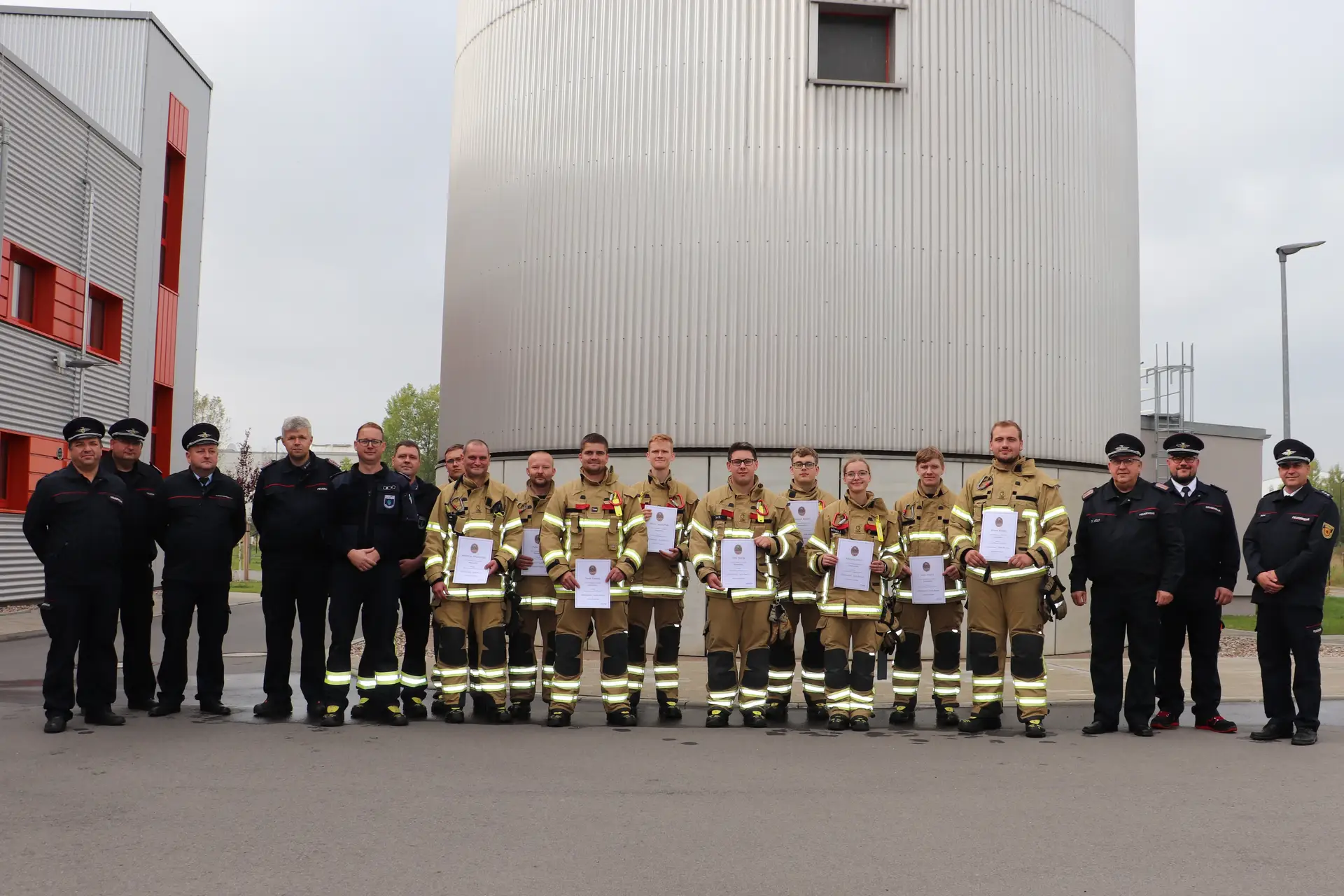 Gruppe der Freiwilligen Feuerwehr Weinböhla mit Urkunden und Wertungsrichtern.